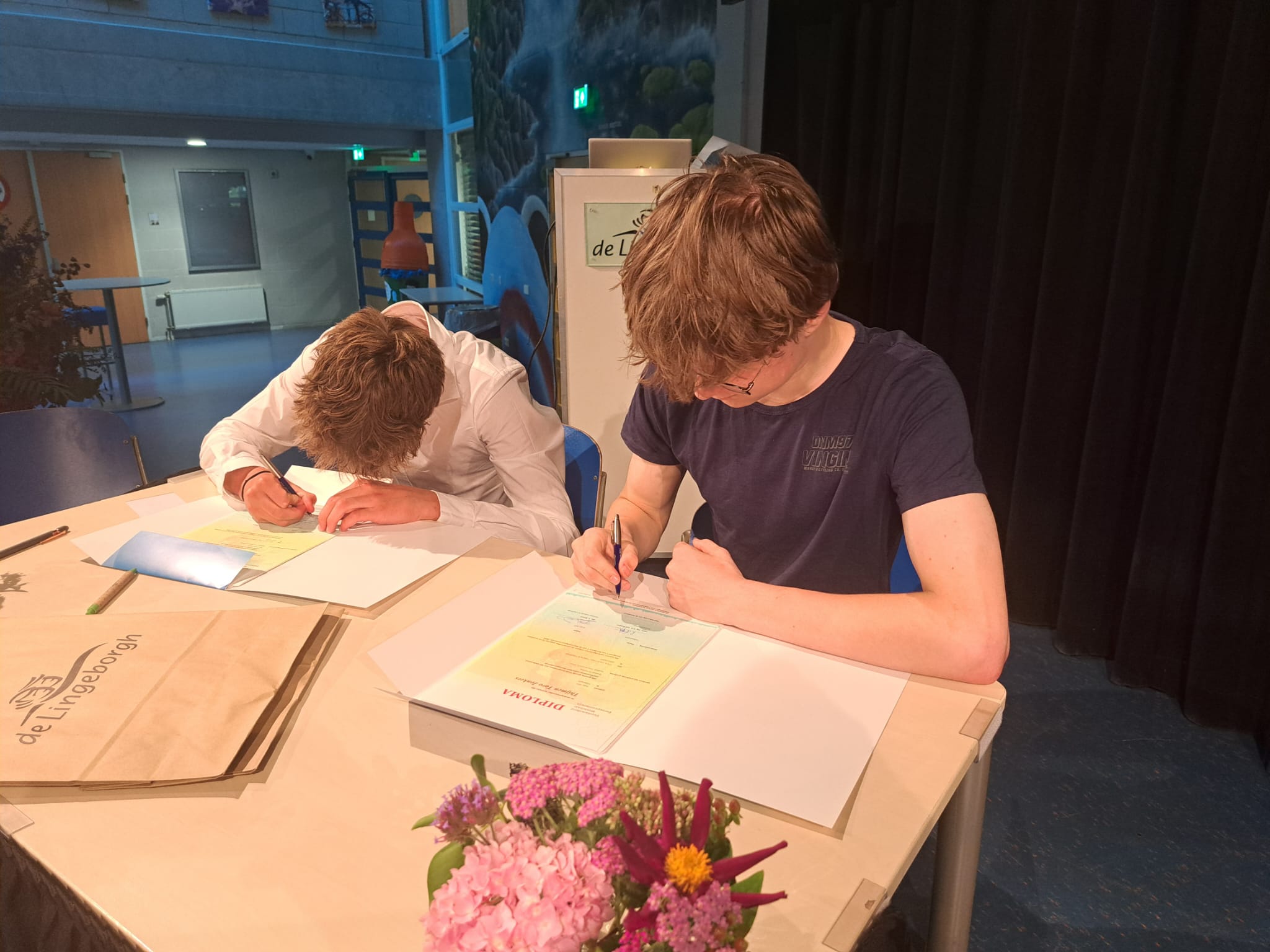 Thijmen tekent zijn diploma